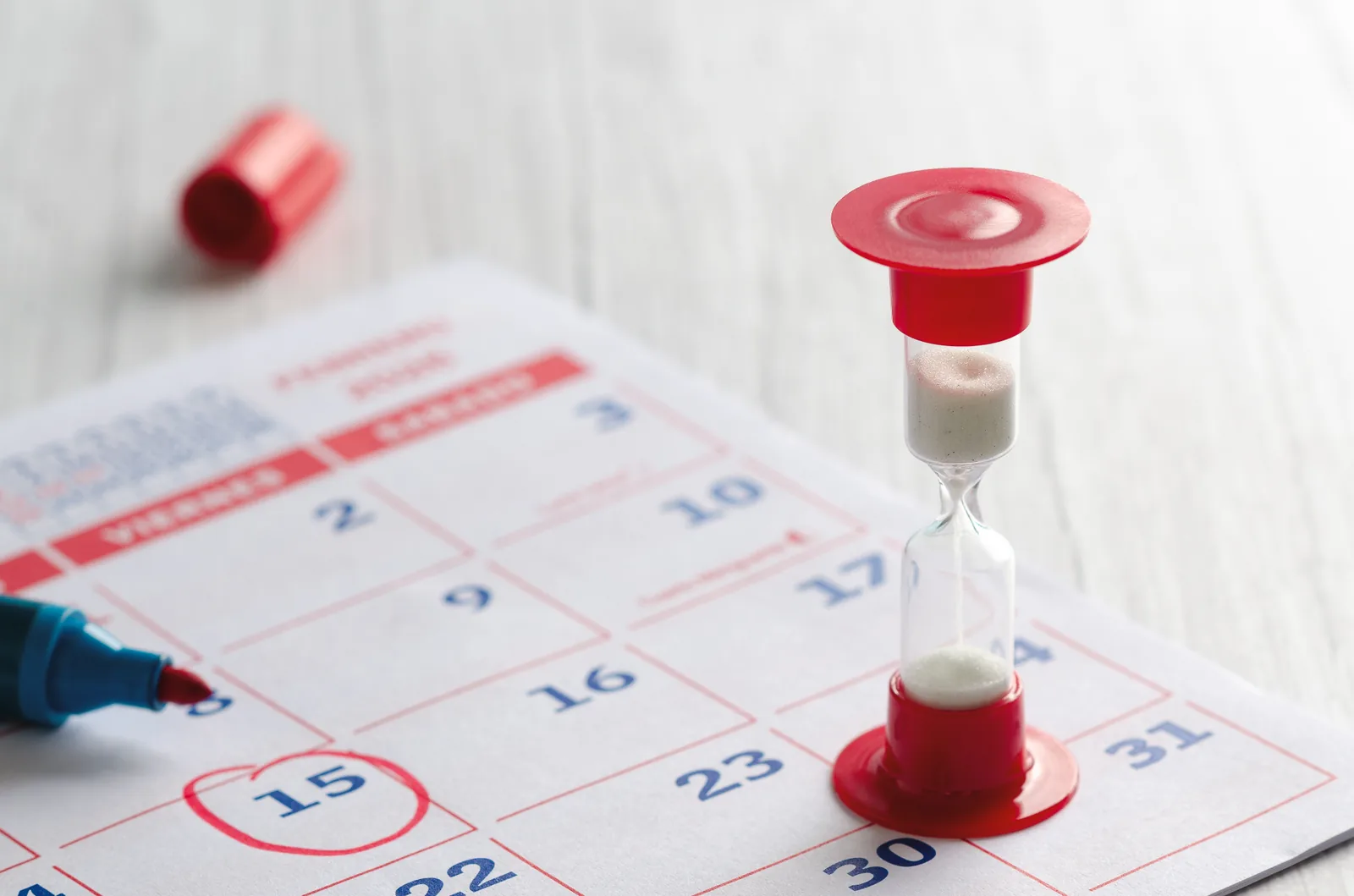 Hourglass on a calendar illustrating estate administration delays, executor timing obligations and potential executor liability.