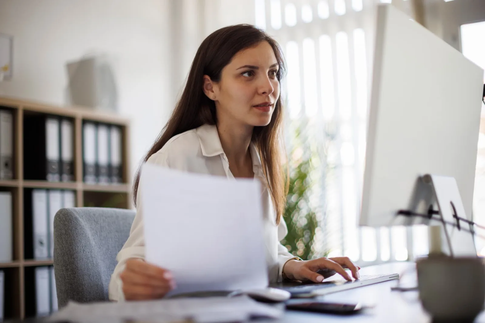 Professional reviewing documents while searching for a missing estate beneficiary