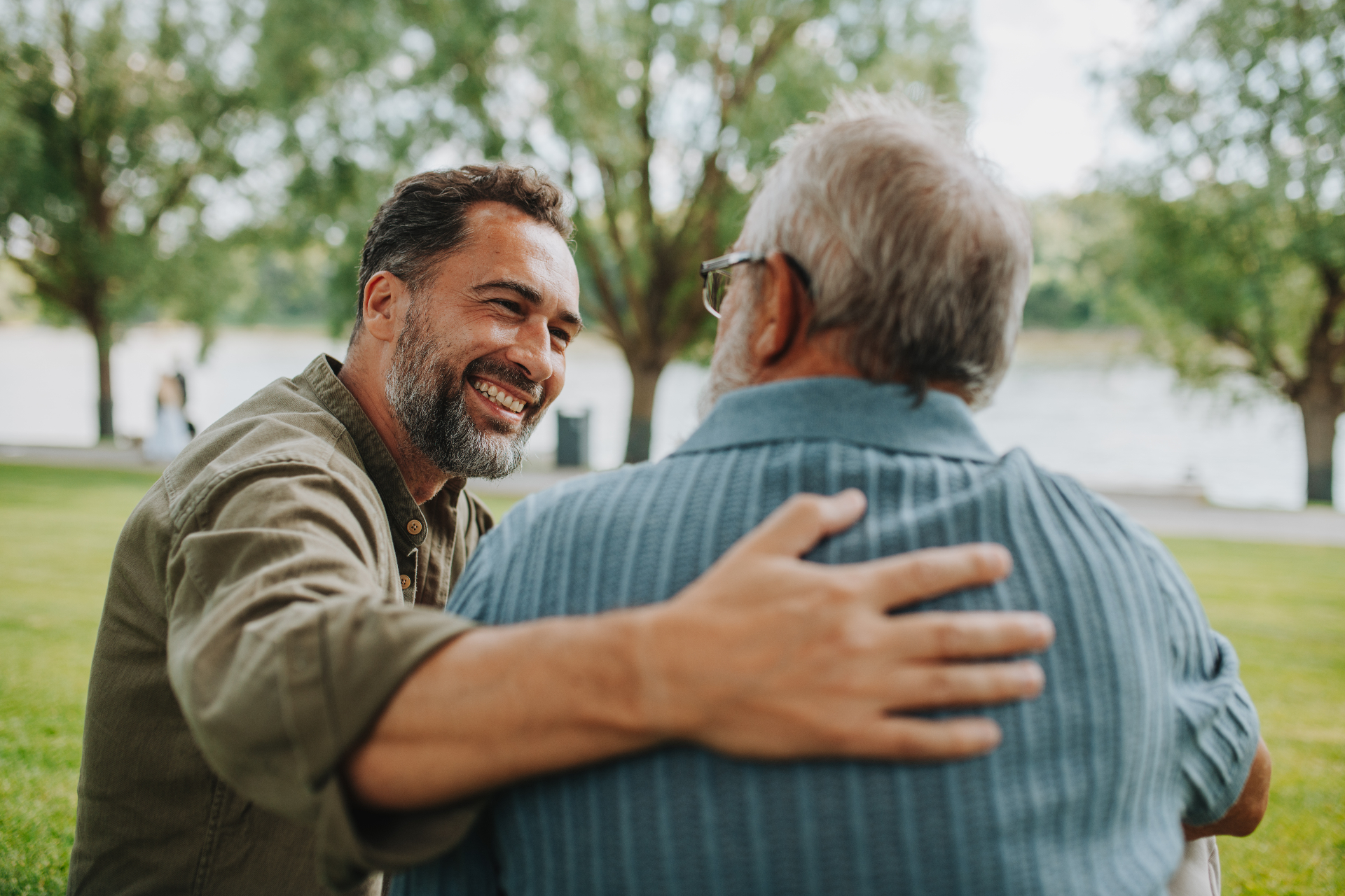Adult son embracing his older father outdoors, representing family support in elder-law and powers-of-attorney matters