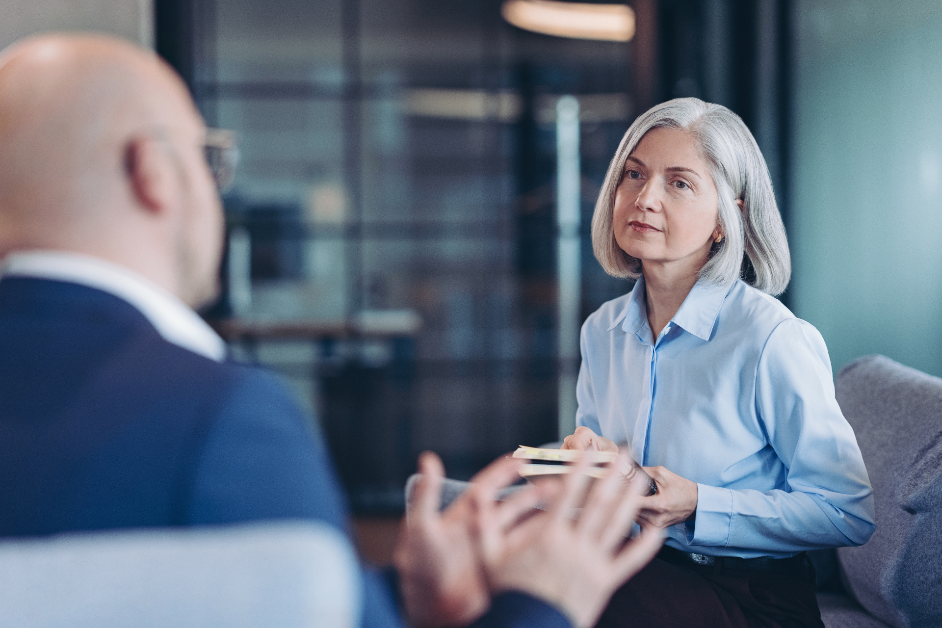 Older woman listening intently to a lawyer during an estate litigation consultation