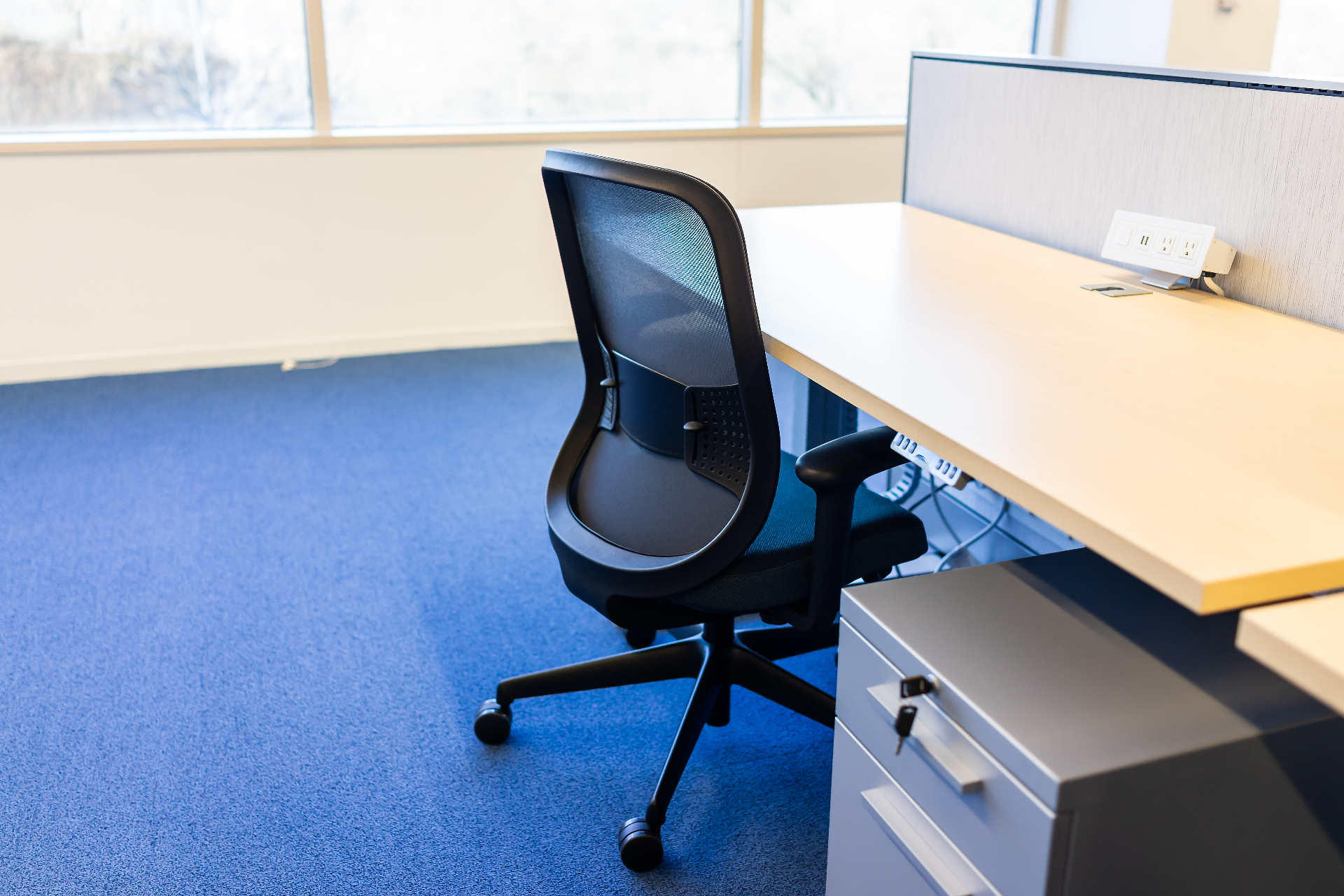 Empty workplace workstation and office chair representing an employee suspended pending a workplace investigation.