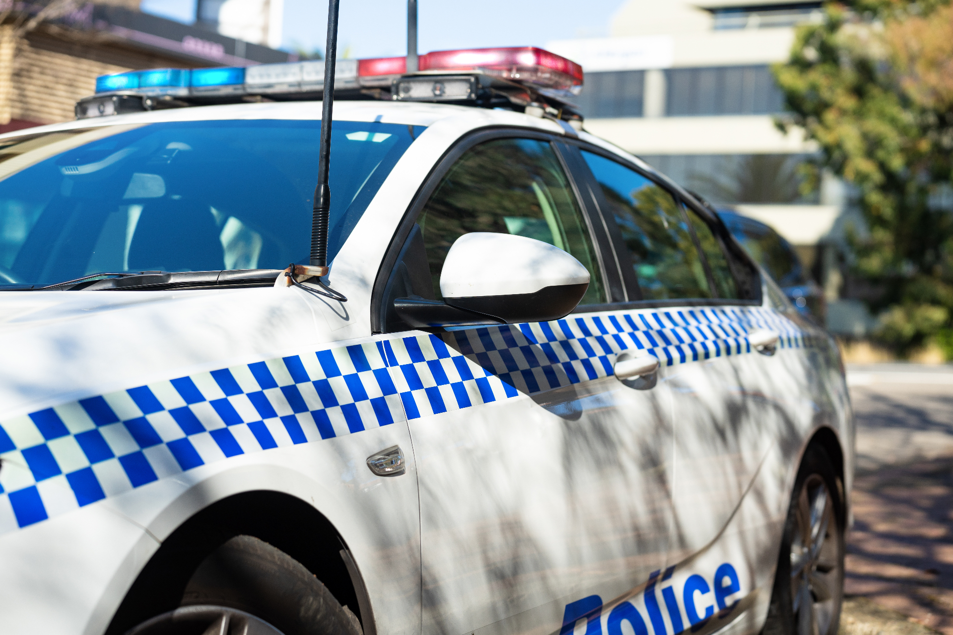 Close-up side view of a Victoria Police patrol sedan with blue and red roof light bars