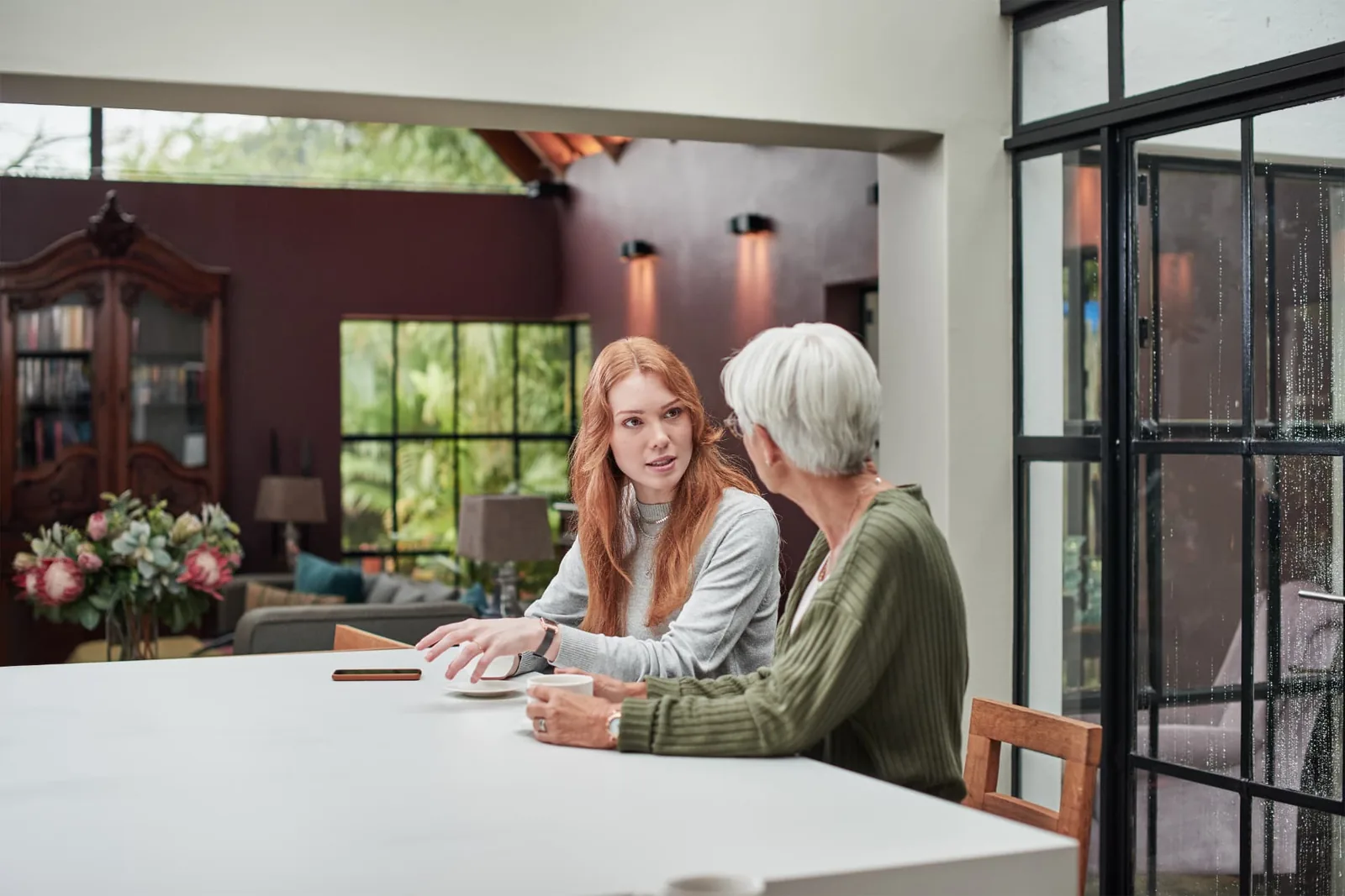 Older woman discussing an aged care assessment decision with a younger family member at home