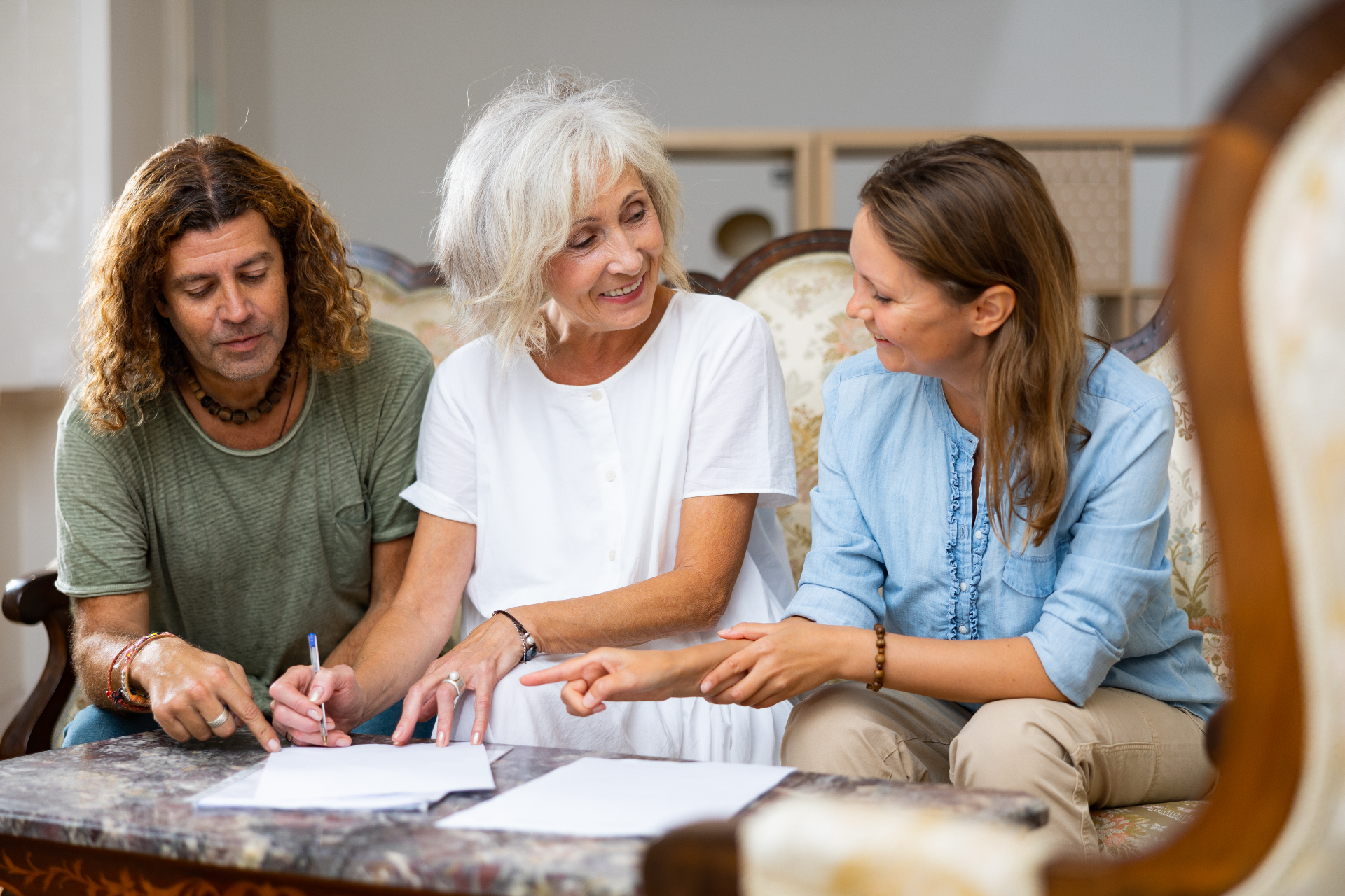 Older woman discussing and signing estate planning documents with family members