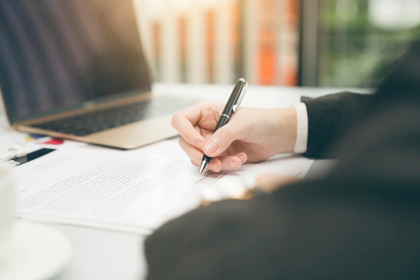 A person signs an employment agreement at a desk — enforcing post-employment restraints of trade in Australia