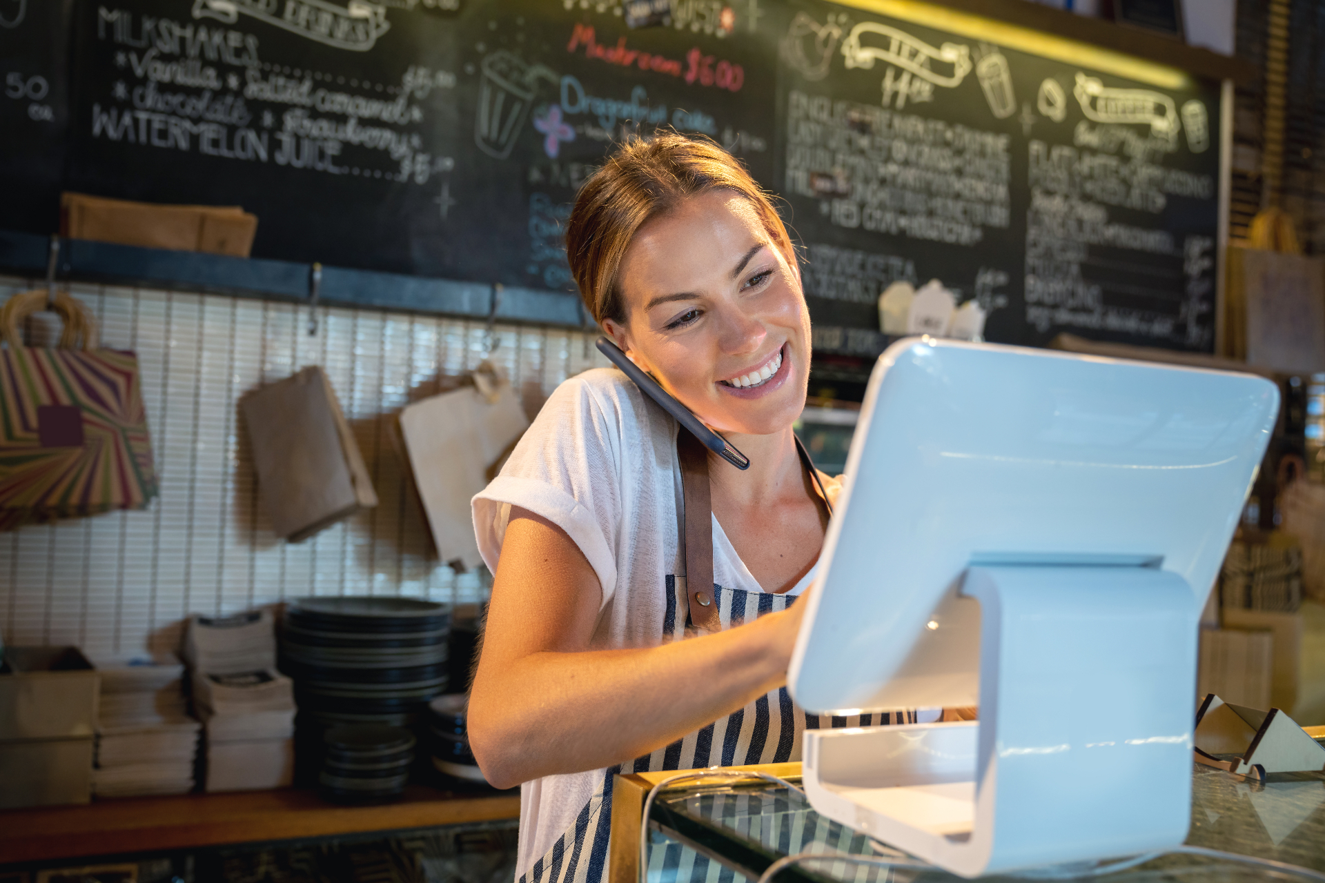 Small business owner using a point-of-sale system in her shop
