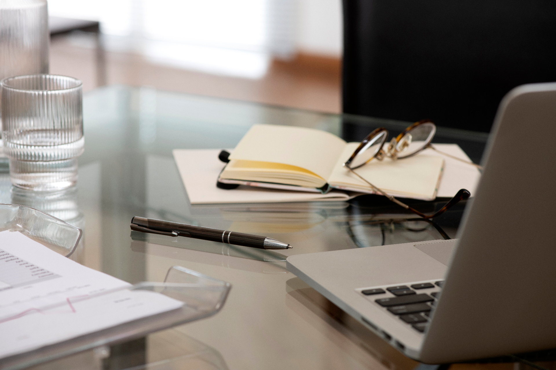 Desk with legal documents, notebook, glasses and laptop