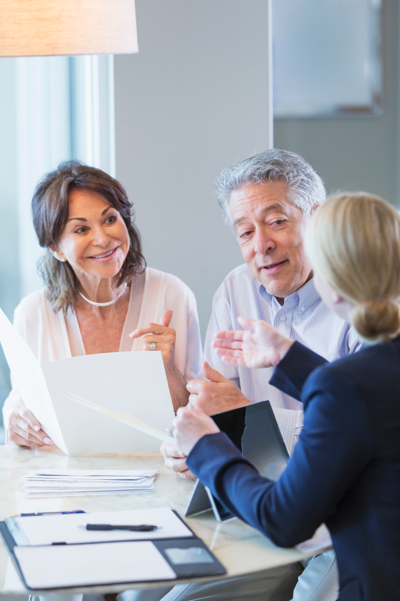 Older couple discussing retirement living and aged care documents with an adviser