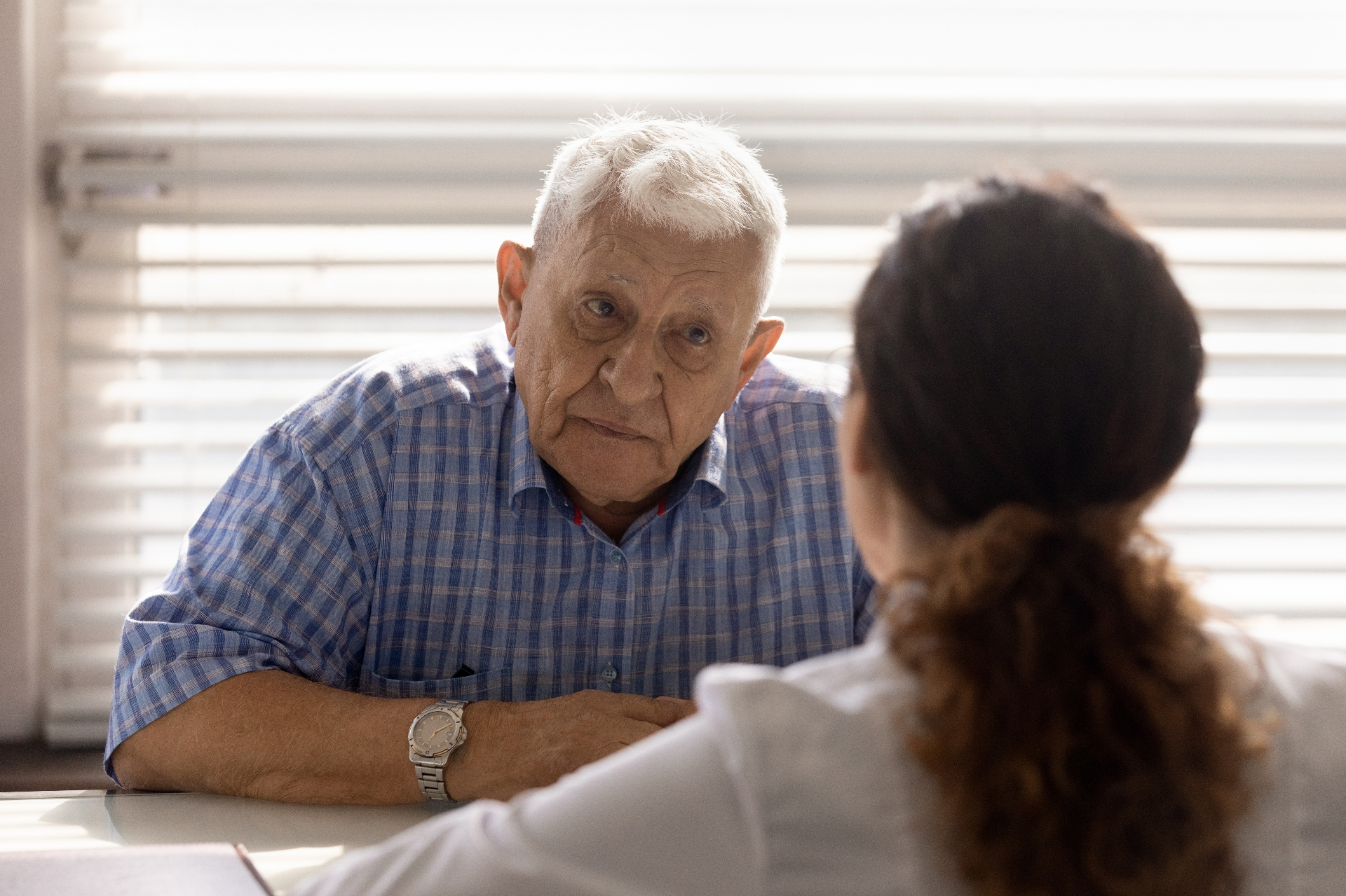 Older man discussing concerns about an enduring power of attorney with a professional adviser