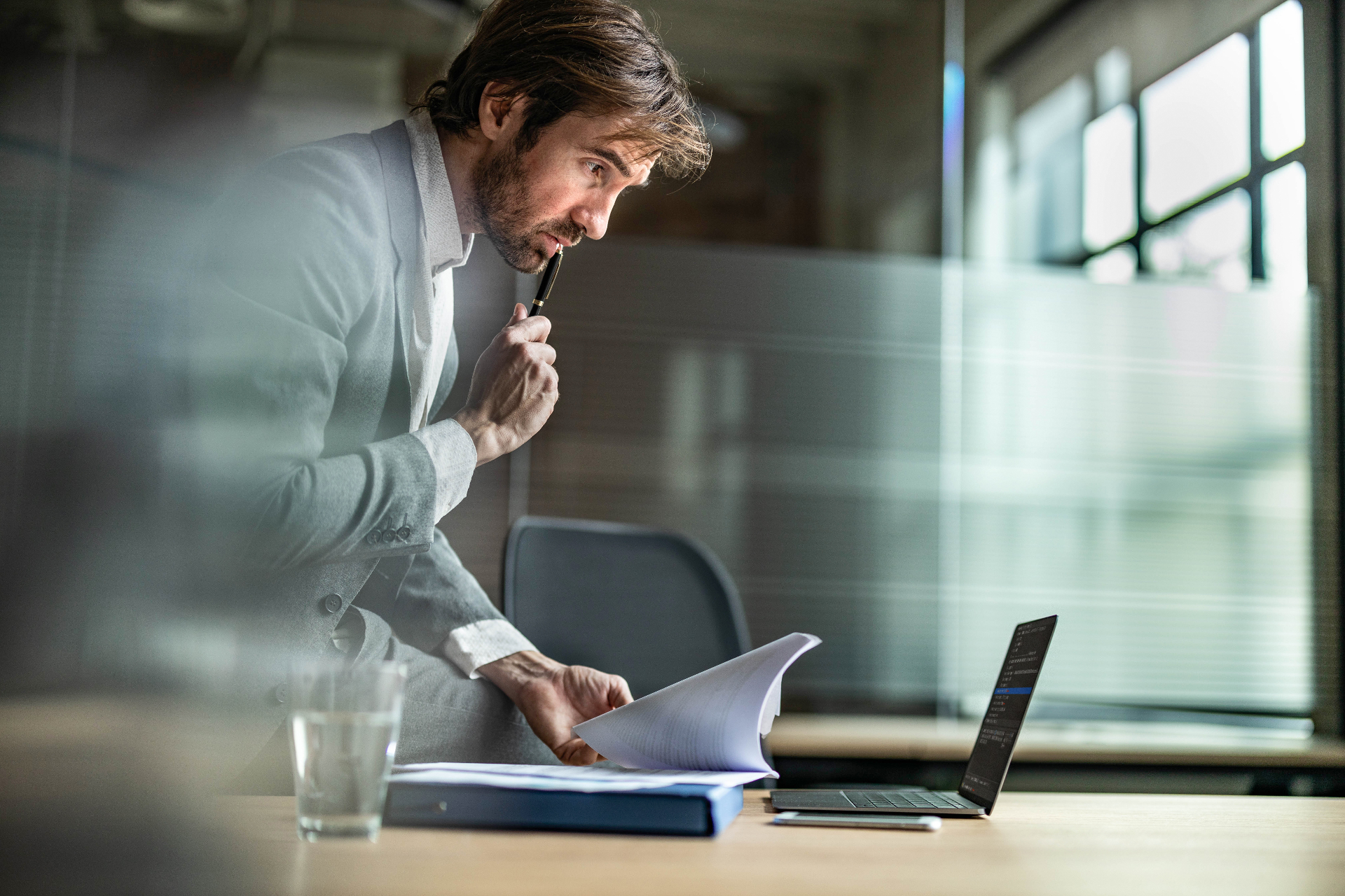 A business person reviews legal documents beside a laptop — enforcing a judgment debt in Victoria