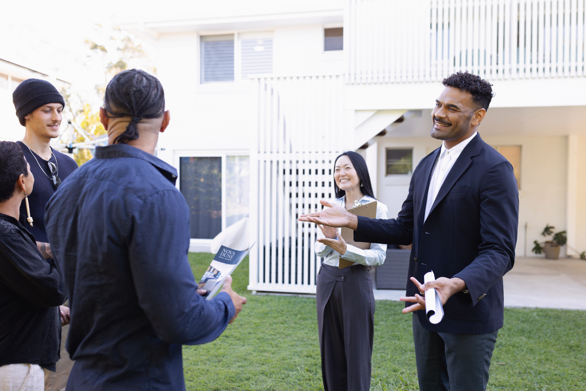 An auctioneer speaks to bidders outside a residential property — selling property at auction in Victoria