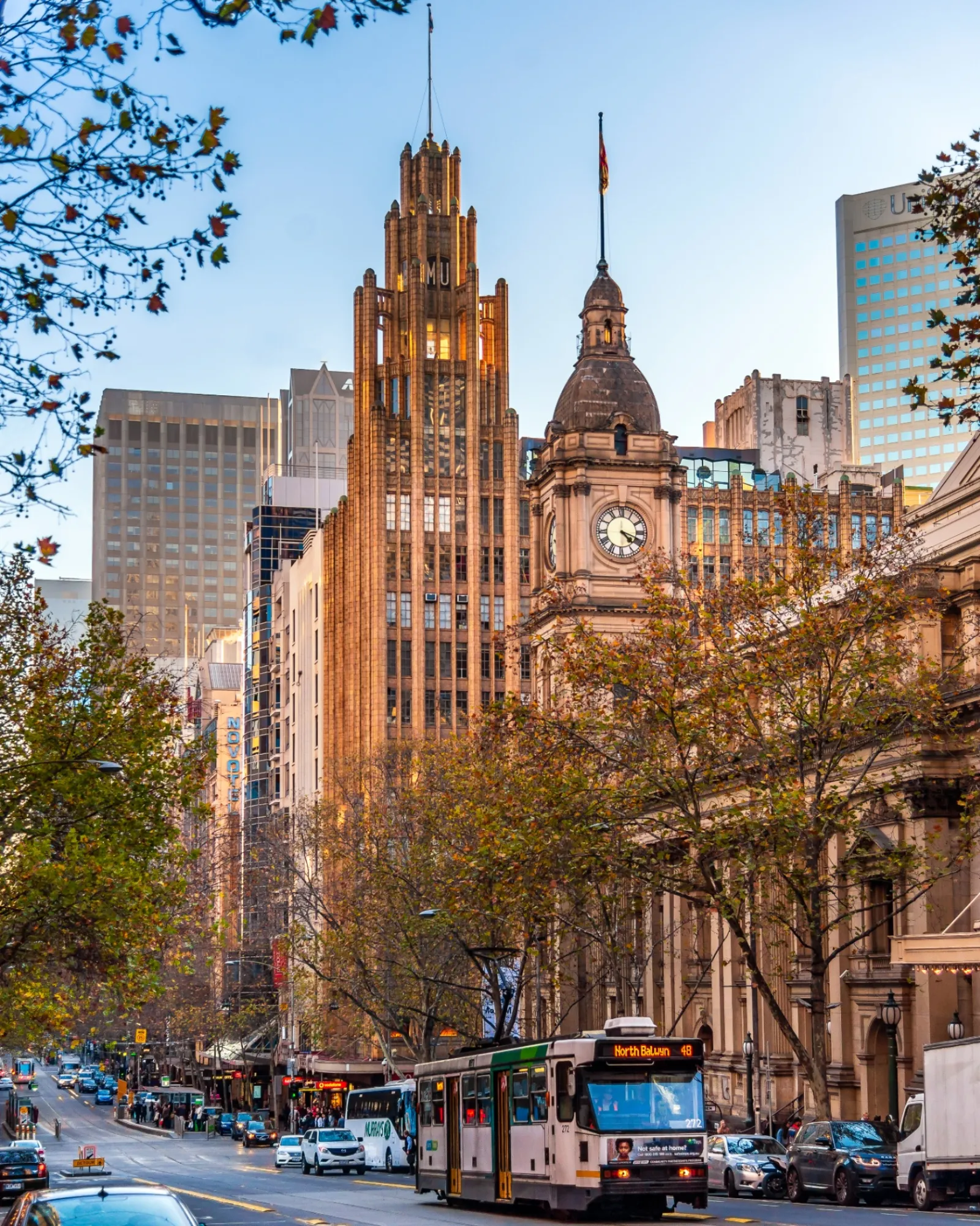 Melbourne CBD streetscape — Manchester Unity Building, Town Hall clock tower and a city tram on Collins Street