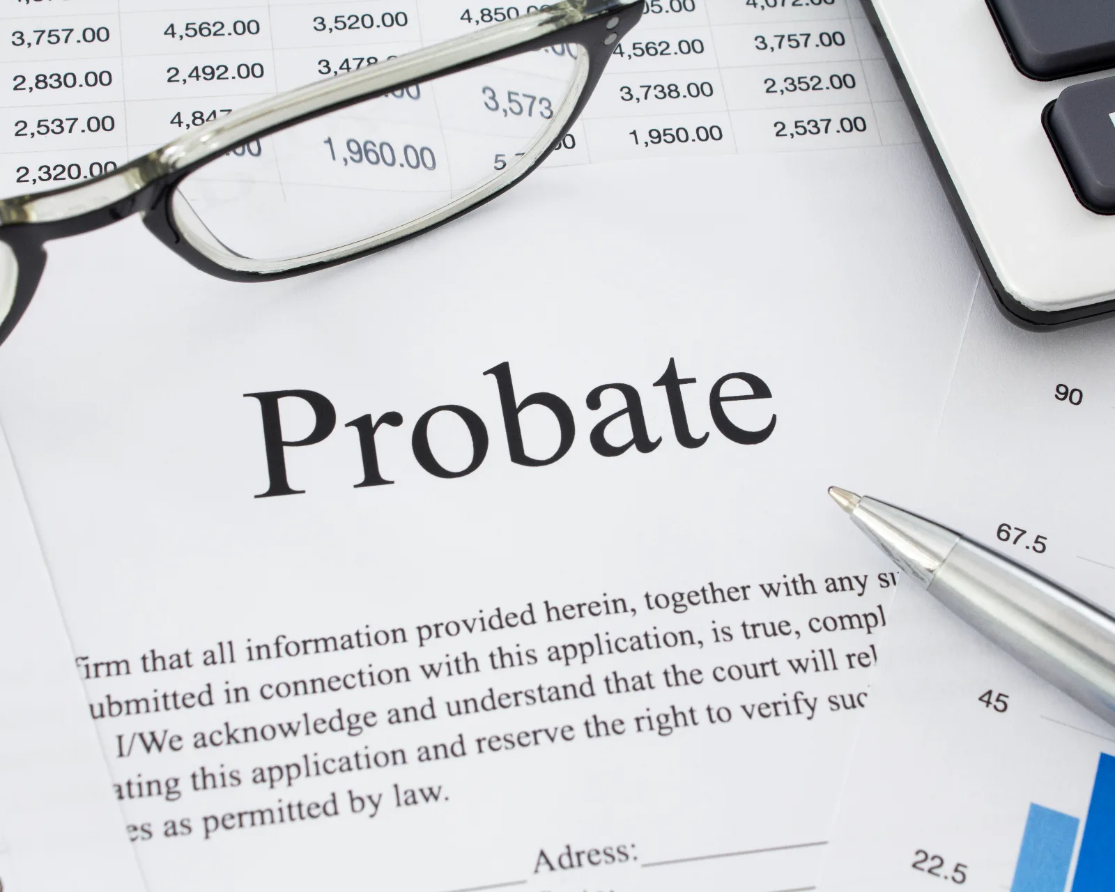 Probate application document with reading glasses, calculator and estate paperwork